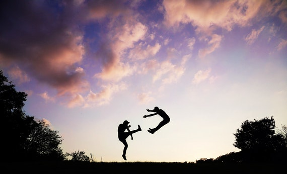 Dua orang sedang karate saat matahari terbenam
