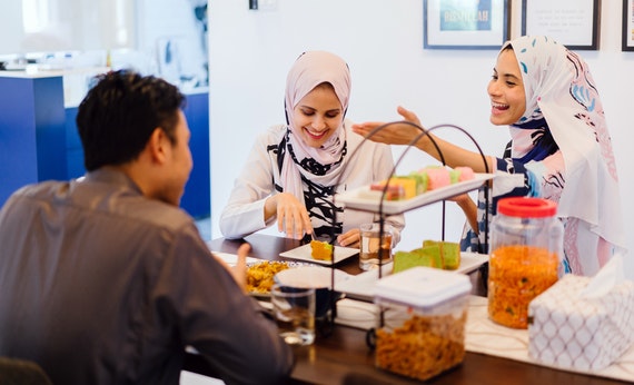 Tiga orang muslim sedang makan bersama