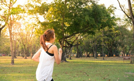 Perempuan sedang berolahraga lari sore di taman
