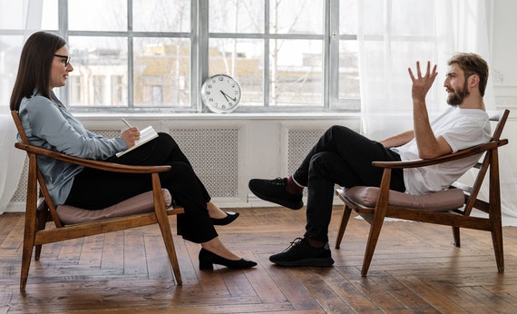 Men and women talking sit in chair
