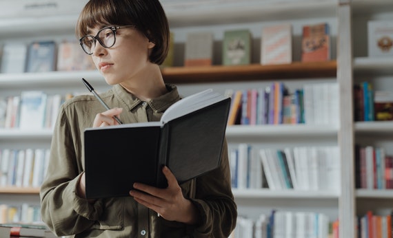 Perempuan jomblo sedang menulis di buku