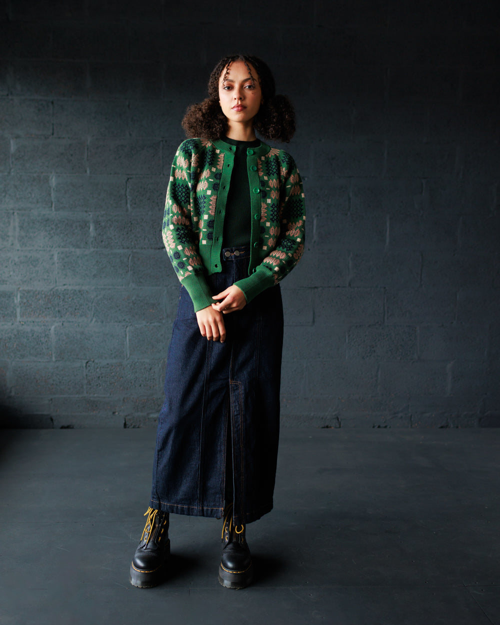 Model wearing the MABLI Carthen jacquard cardigan in green with a long denim skirt
