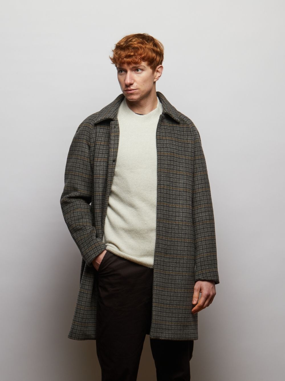 Model wearing the Guards London Coldstream grey microcheck wool overcoat over a cream sweater