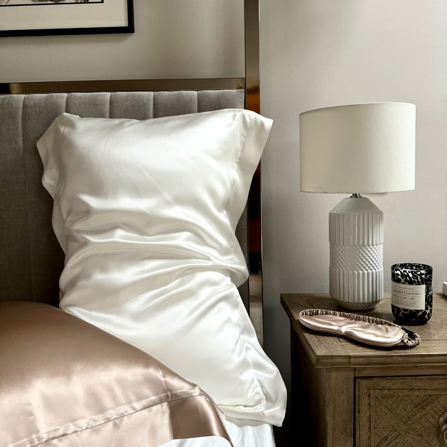 Silk Works ivory silk pillowcase with Oxford border on a made bed beside a lamp