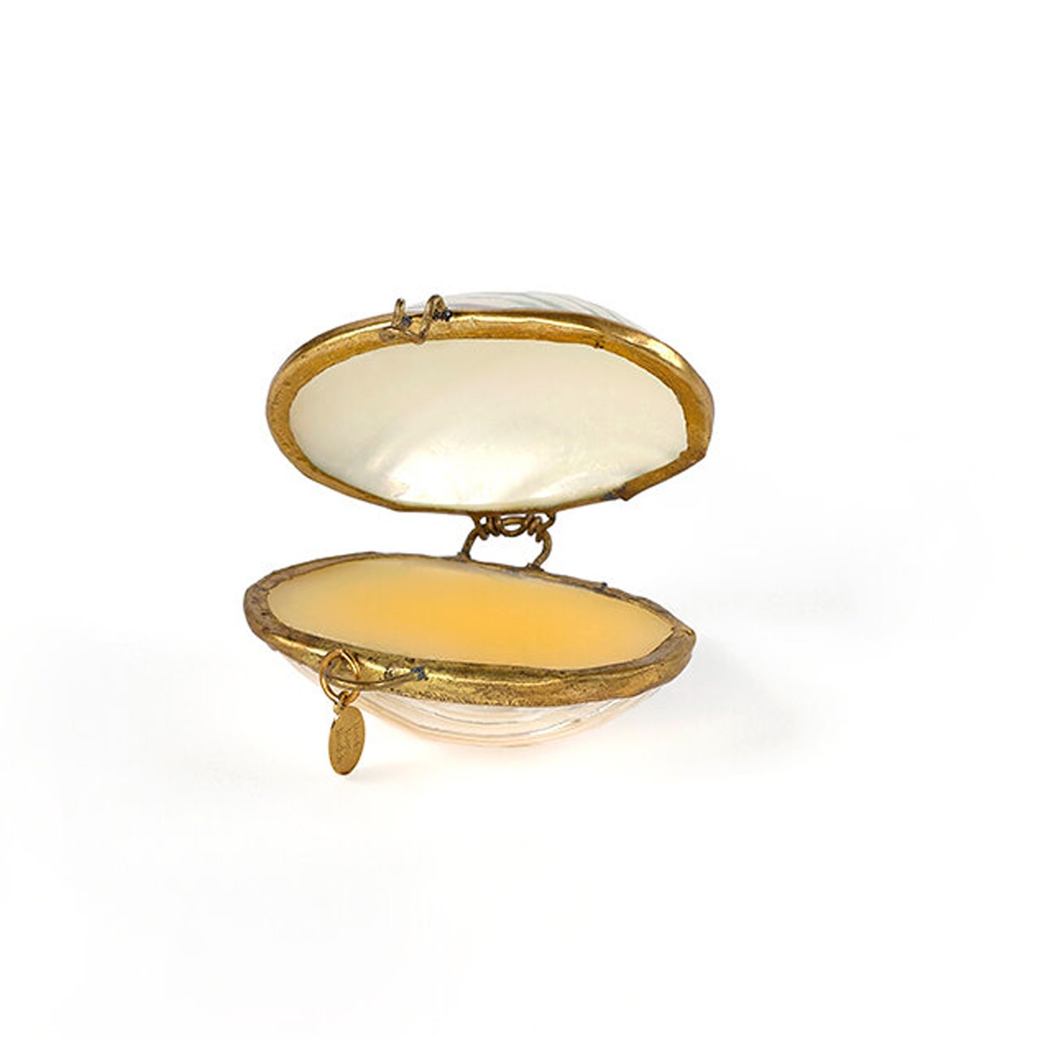Roots Rose Radish solid scent inside an open white pearl turbo seashell with gold clasp