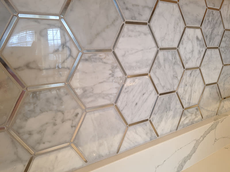 Marble hexagon backsplash tile with mirrored chrome inlay strips