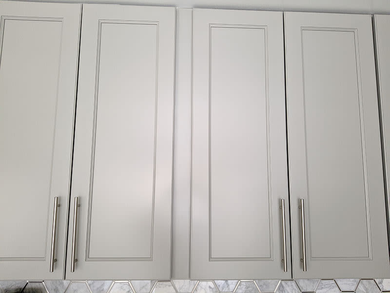 Close-up of grey shaker cabinet doors with brushed nickel bar pulls