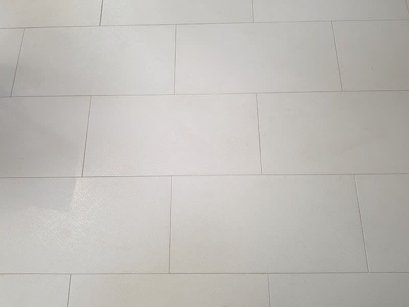 Large-format off-white porcelain floor tile laid in an offset pattern