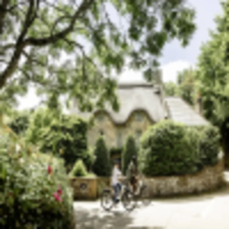 Radfahrer am Reetdachhaus