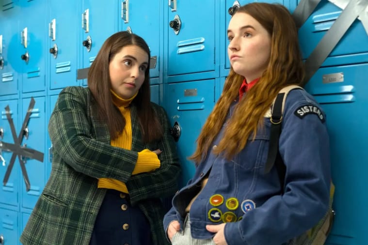 Two women standing next to each other by a locker