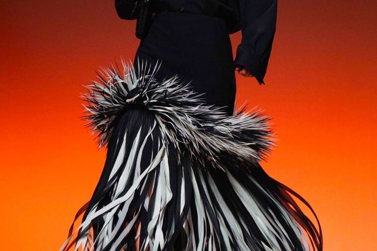 A person wearing a black and white feathered skirt