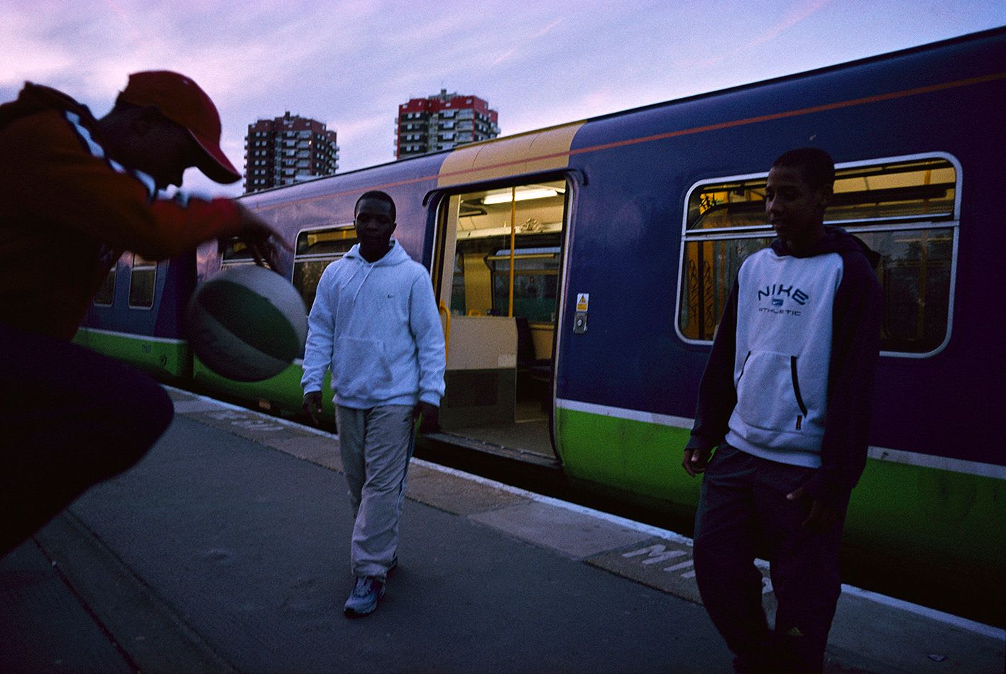 Teen boys playing basketball on a train platform