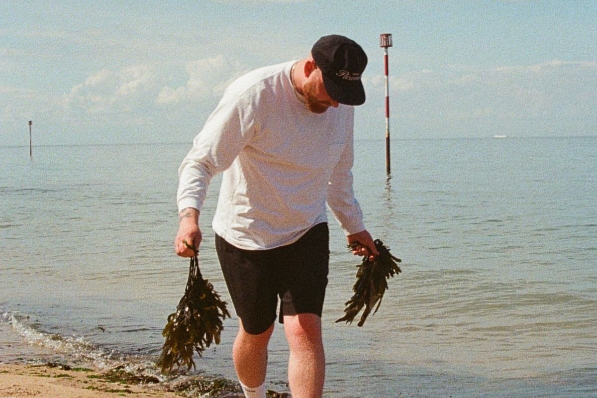 Haeckels employee on Margate beach holding seaweed 