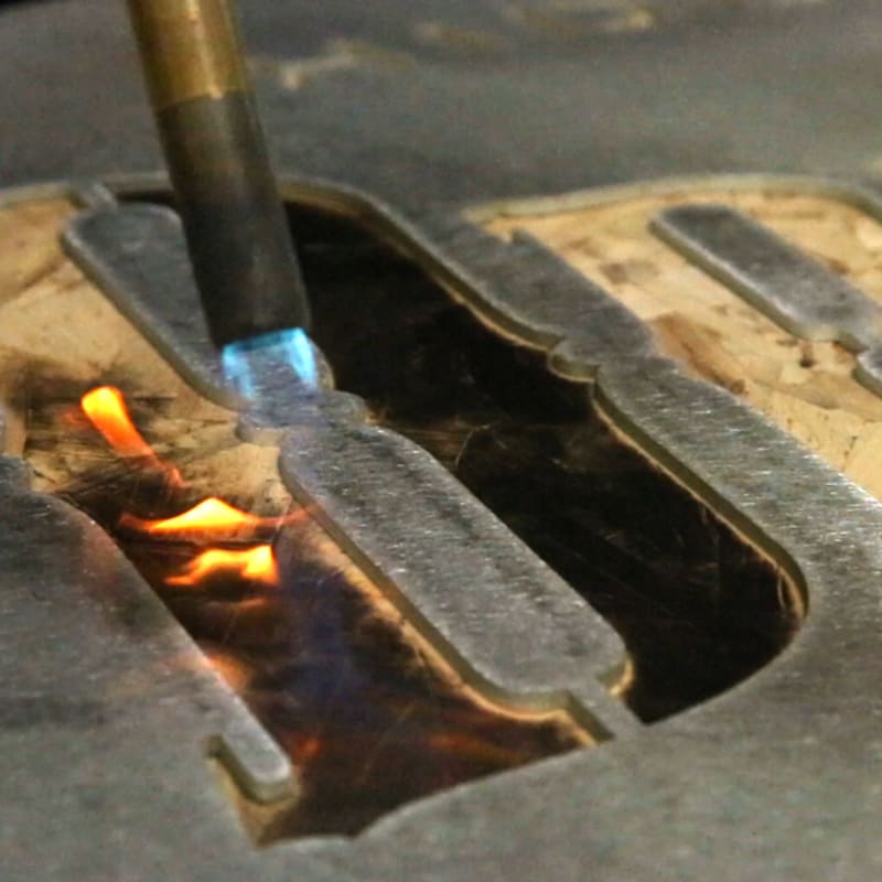 Person Holding a Wood Burning Tool, Burning Letters onto Wood