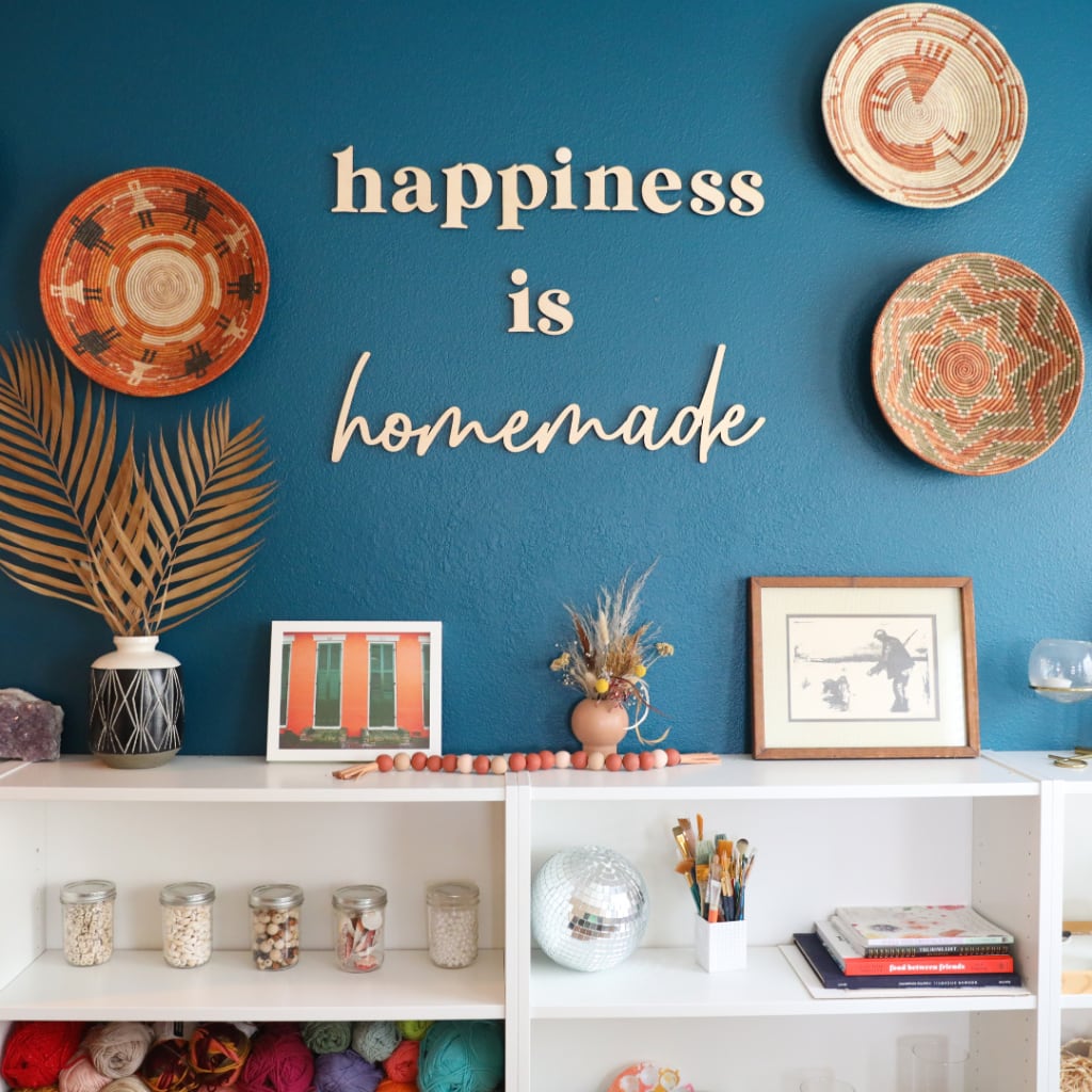 Decorative Letters Forming Word LOVE on Wooden Shelf on White Wall