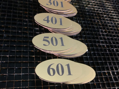 Condominium numbers laser engraved on brushed gold lamacoid.