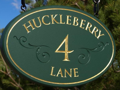 Oval cedar sign with V carved letters with hand painted finish.