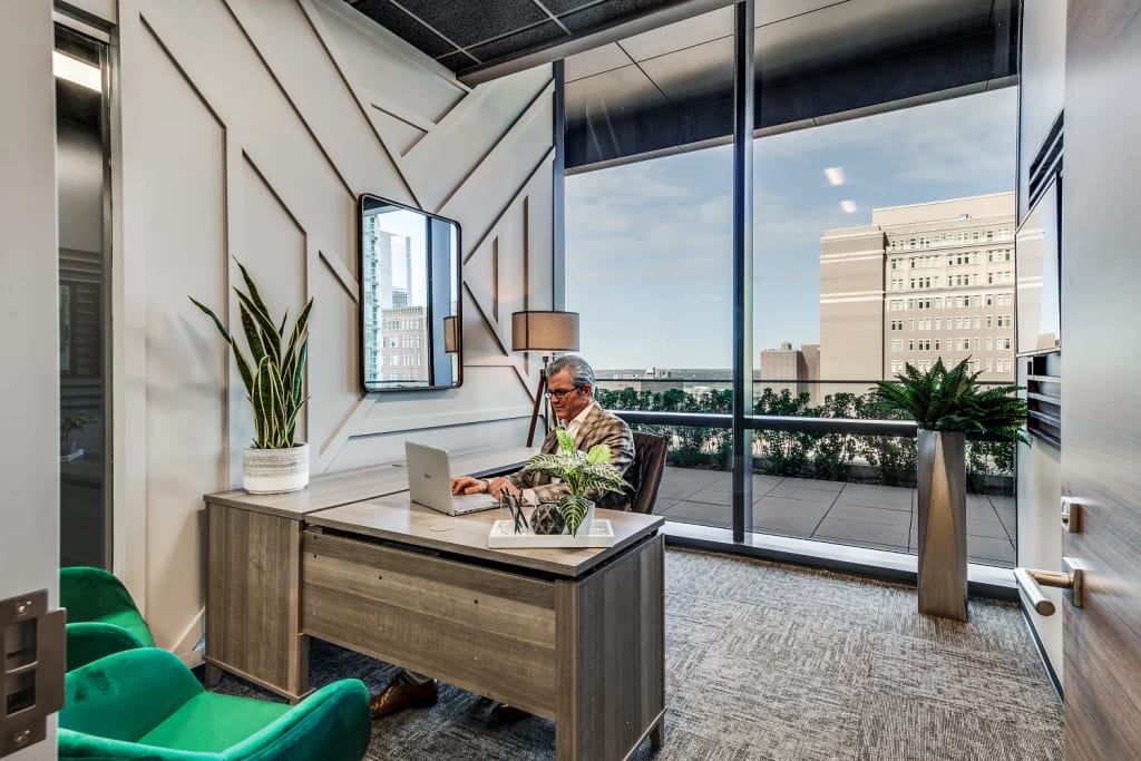 Man sitting in window office at executive desk