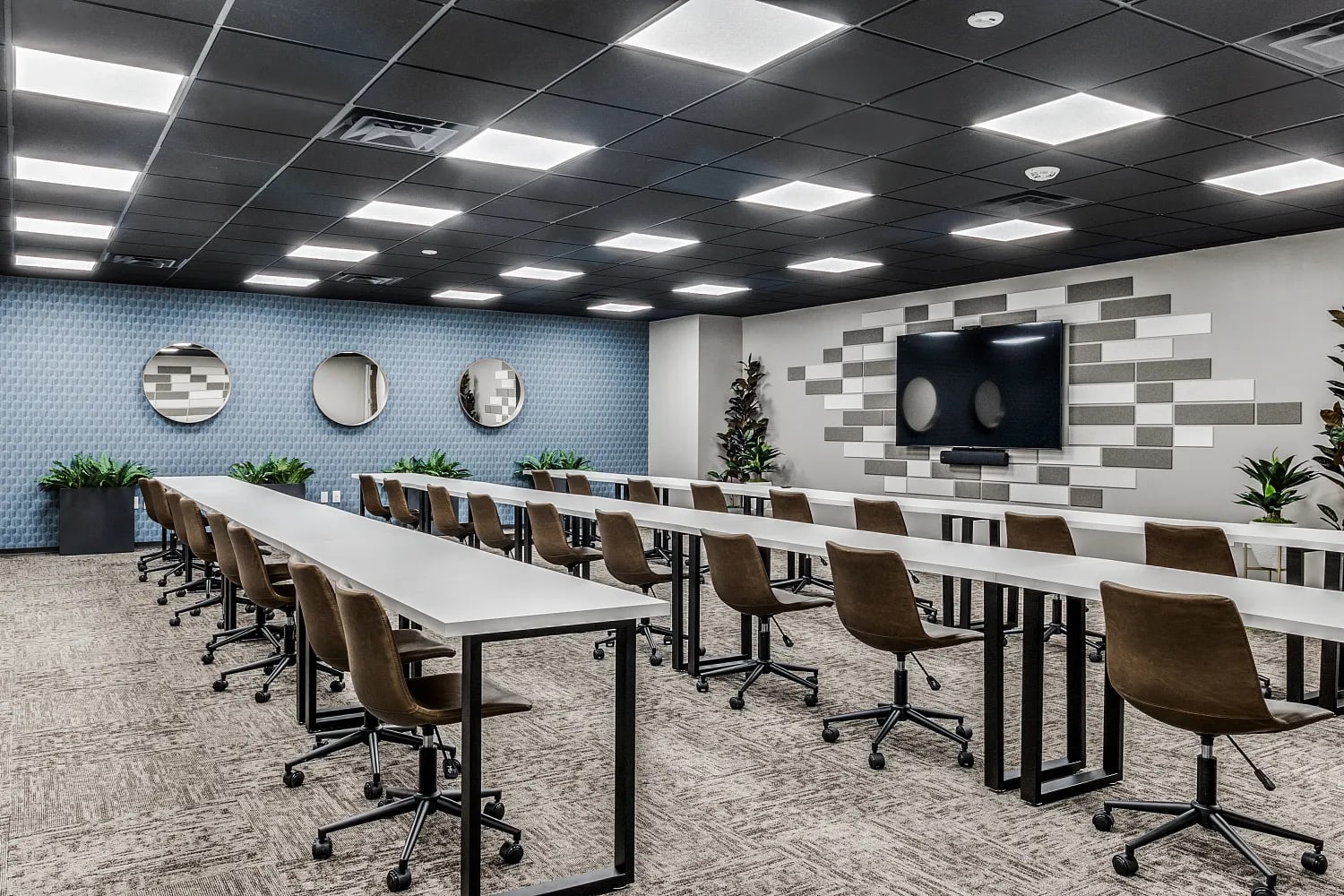 Training room with rows of desks and presentation screen at Lucid Private Offices