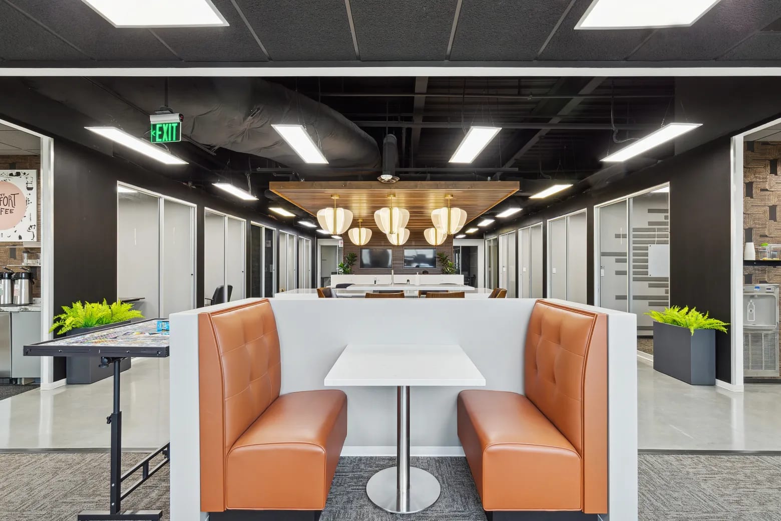Café-style booth seating with orange upholstered seats and pedestal table