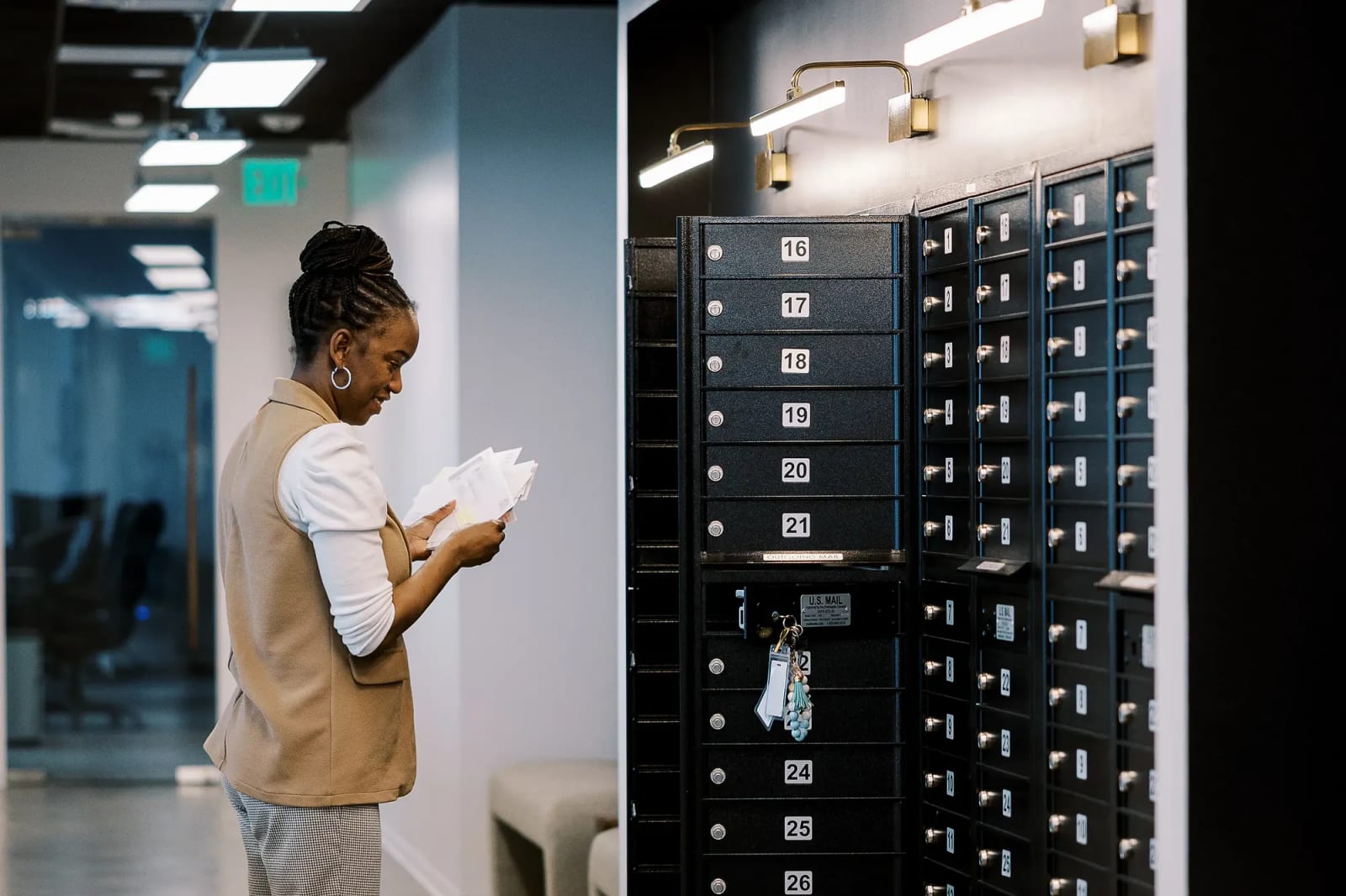 Professional retrieving mail from secure mailboxes in a Houston office workspace.