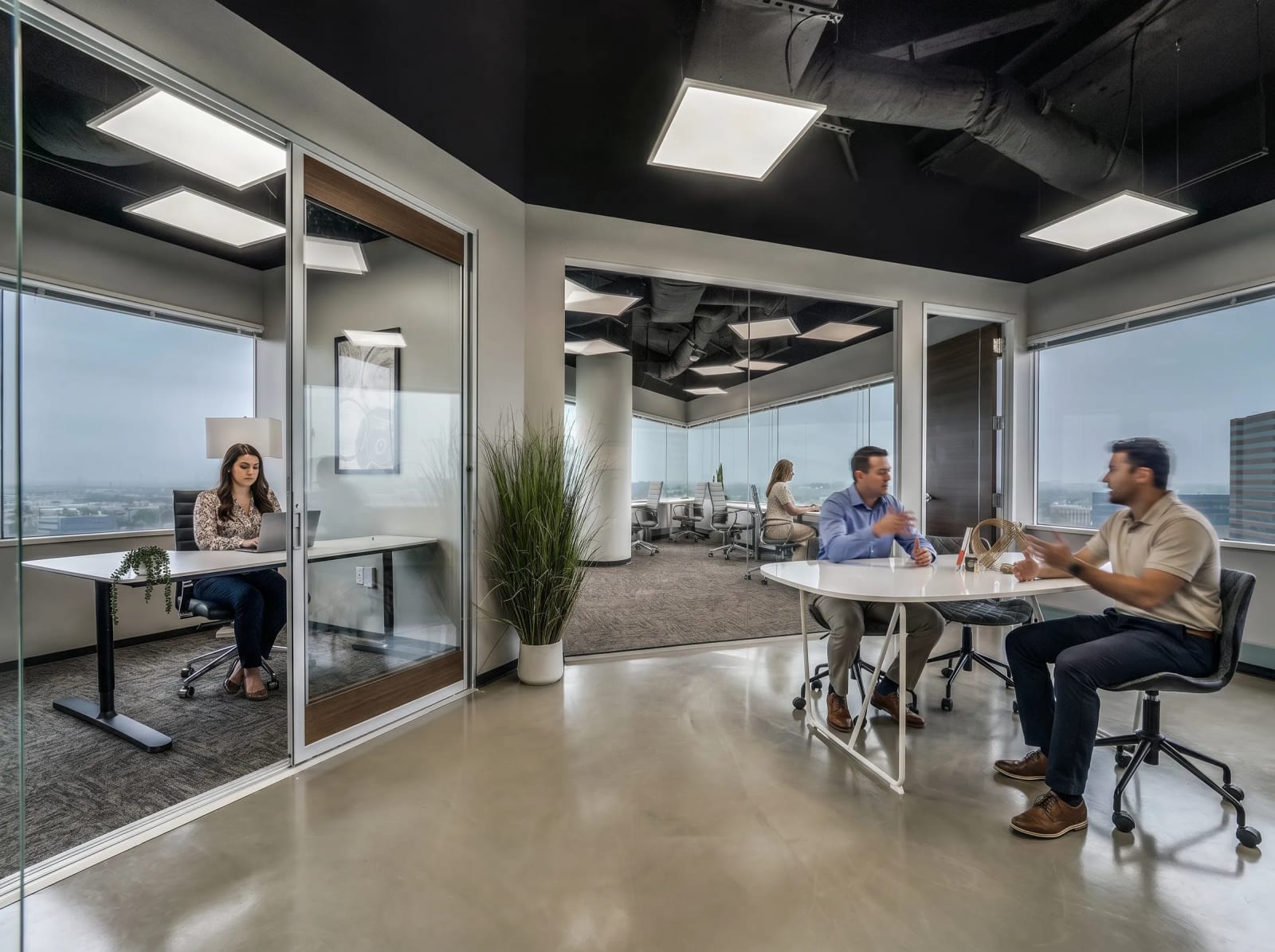 Private office with glass walls and open team workspace at Lucid Private Offices