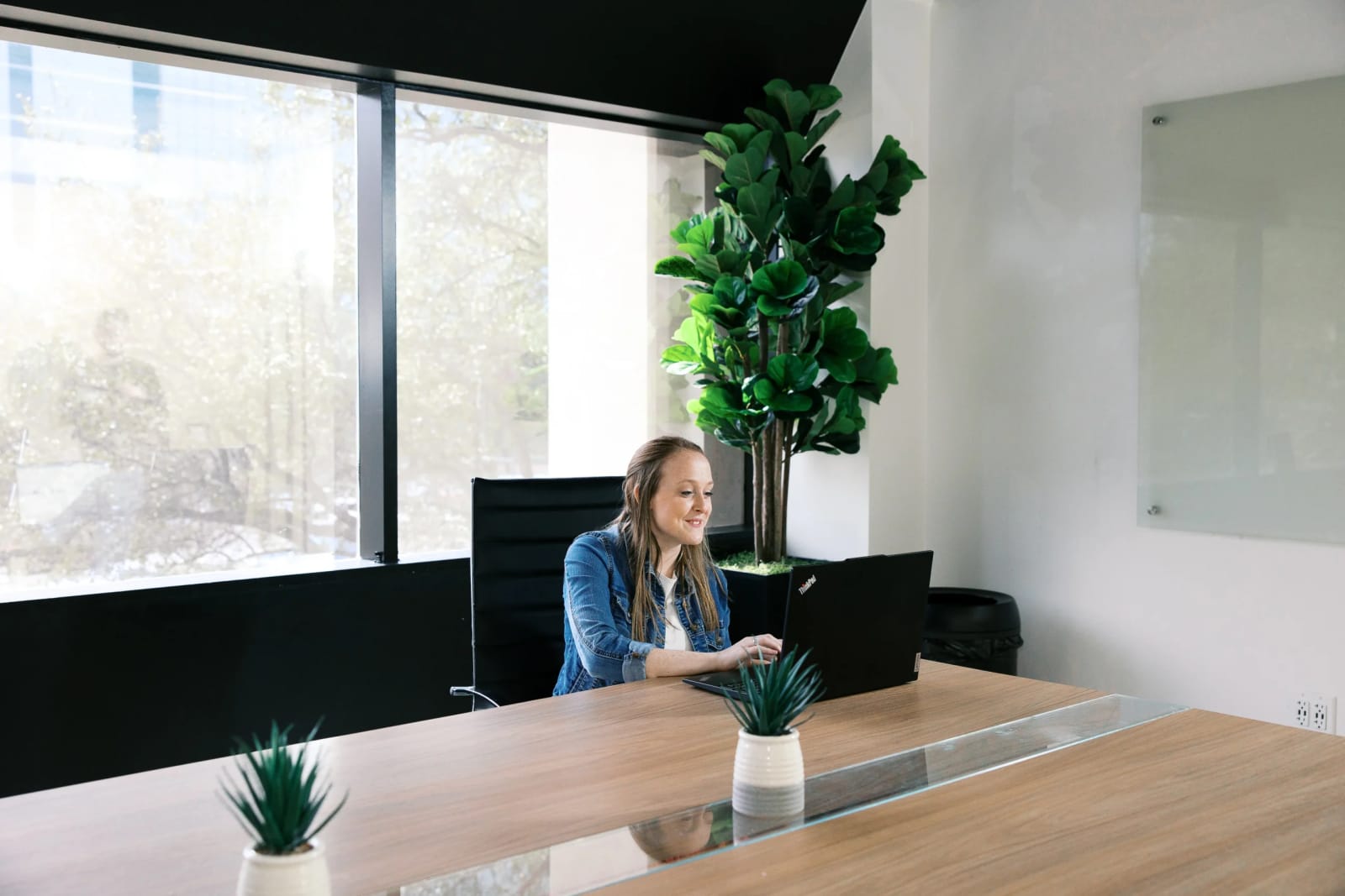 Professional receptionist in a Houston office lobby welcoming guests at the front desk.