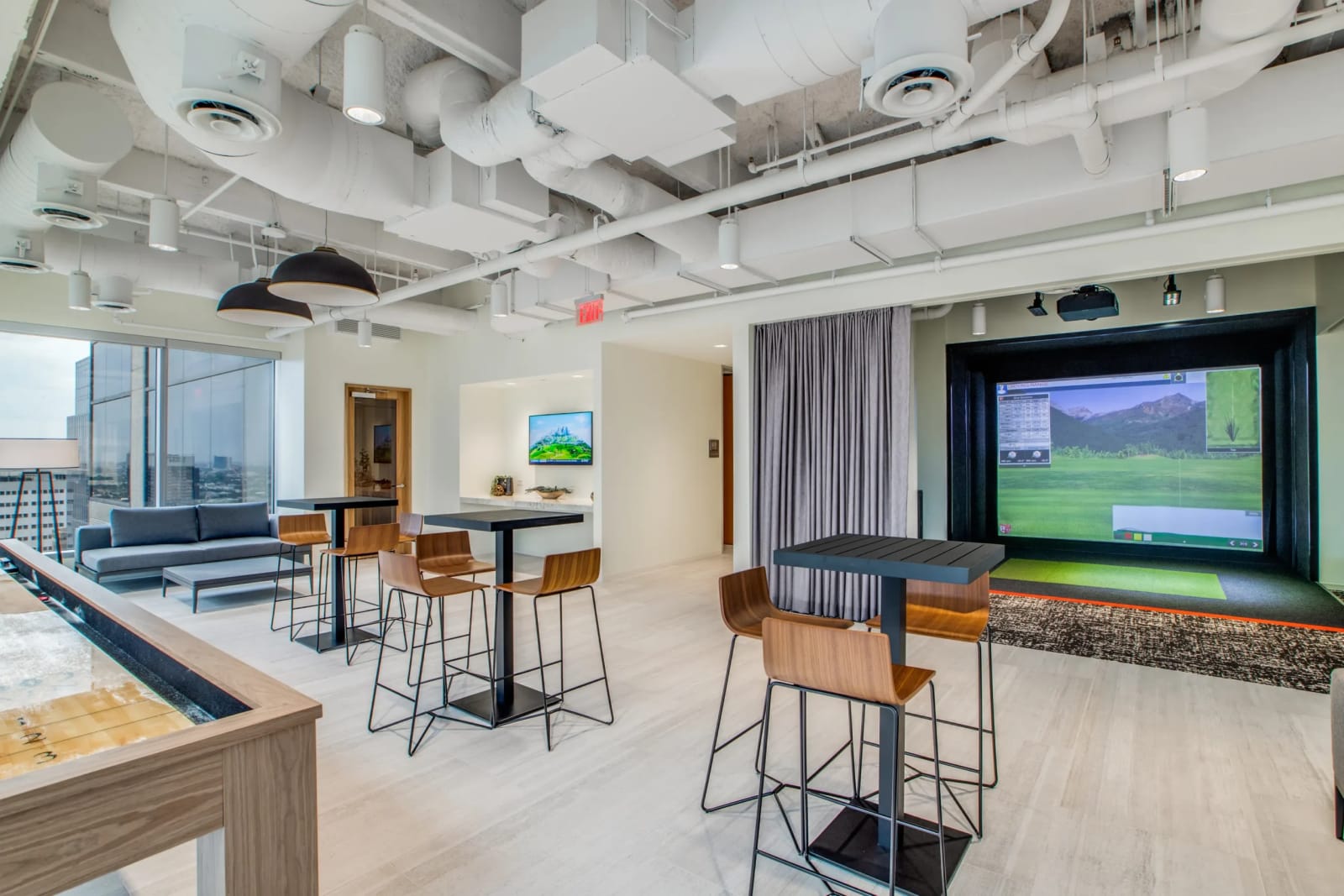 Co-working lounge with large screen and seating at Lucid Private Offices Downtown Houston