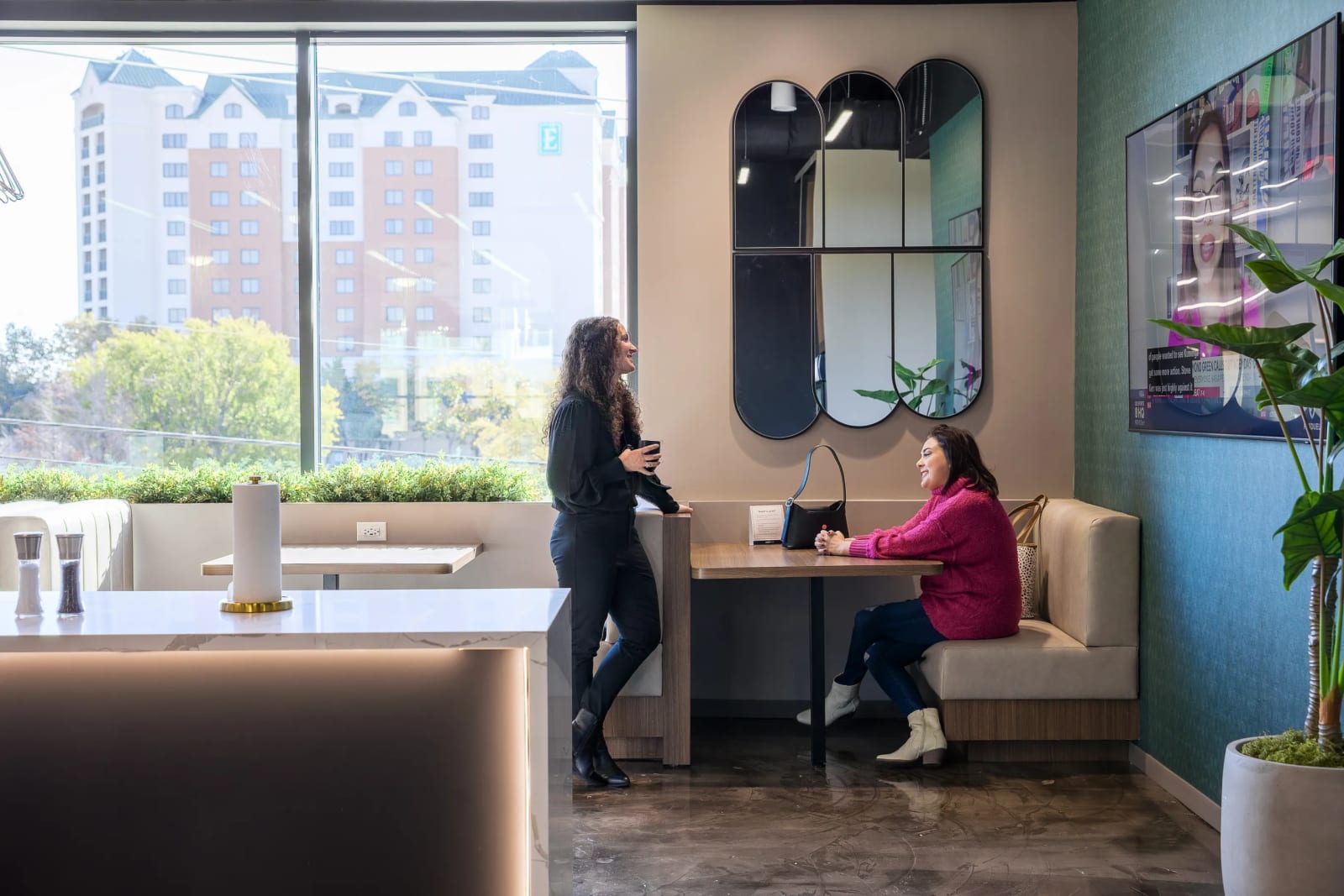 Professionals working at a coworking hot desk near large windows at Lucid Private Offices Grapevine