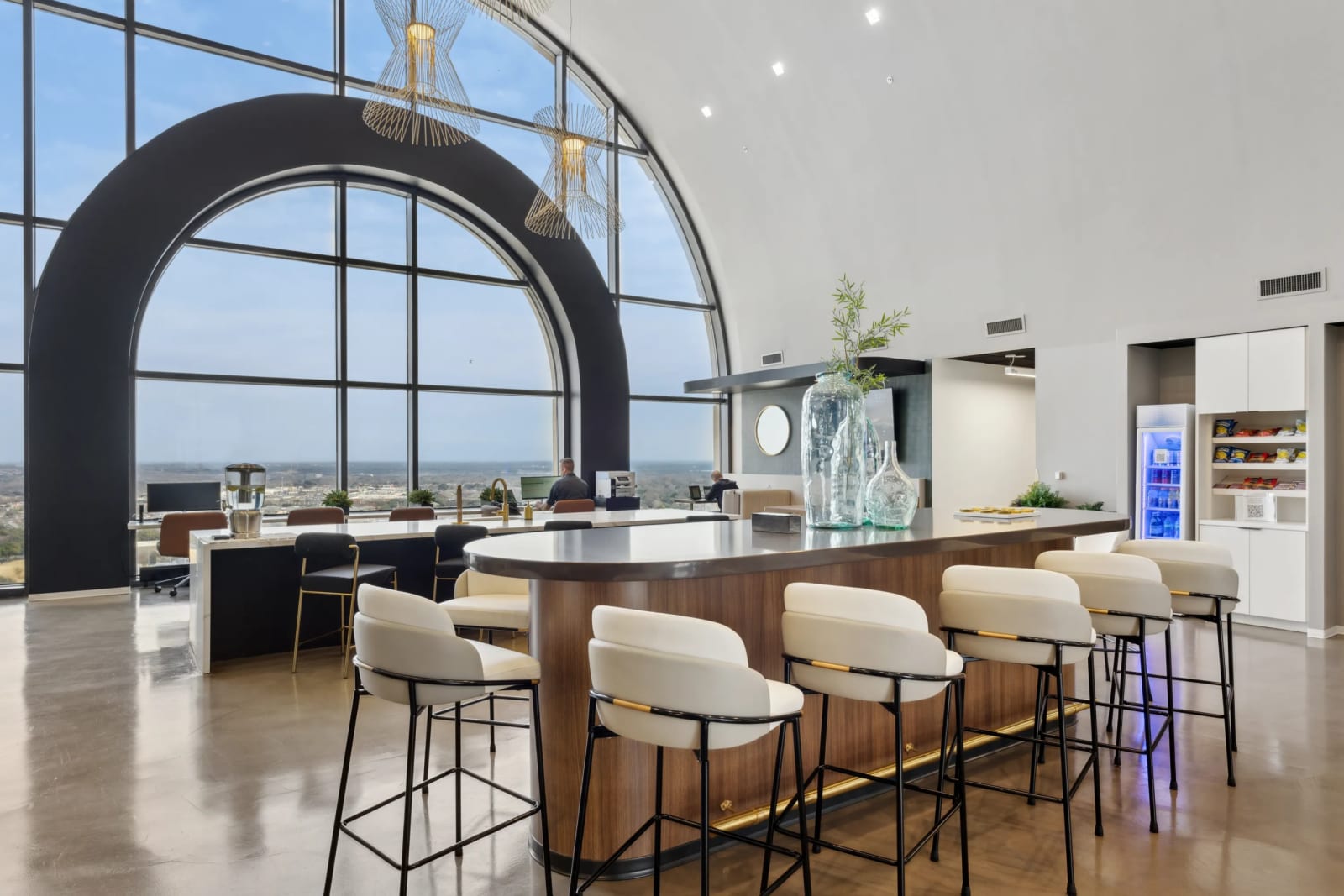 Hot desk bar with arched windows and bar stool seating at Lucid Private Offices coworking space
