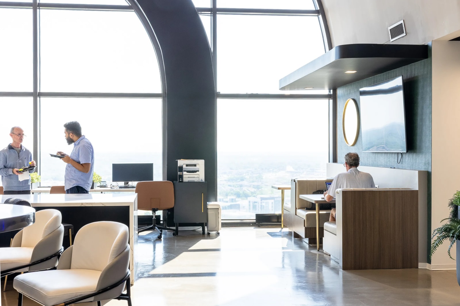 Open coworking area with arched windows and lounge seating at North Central Expressway