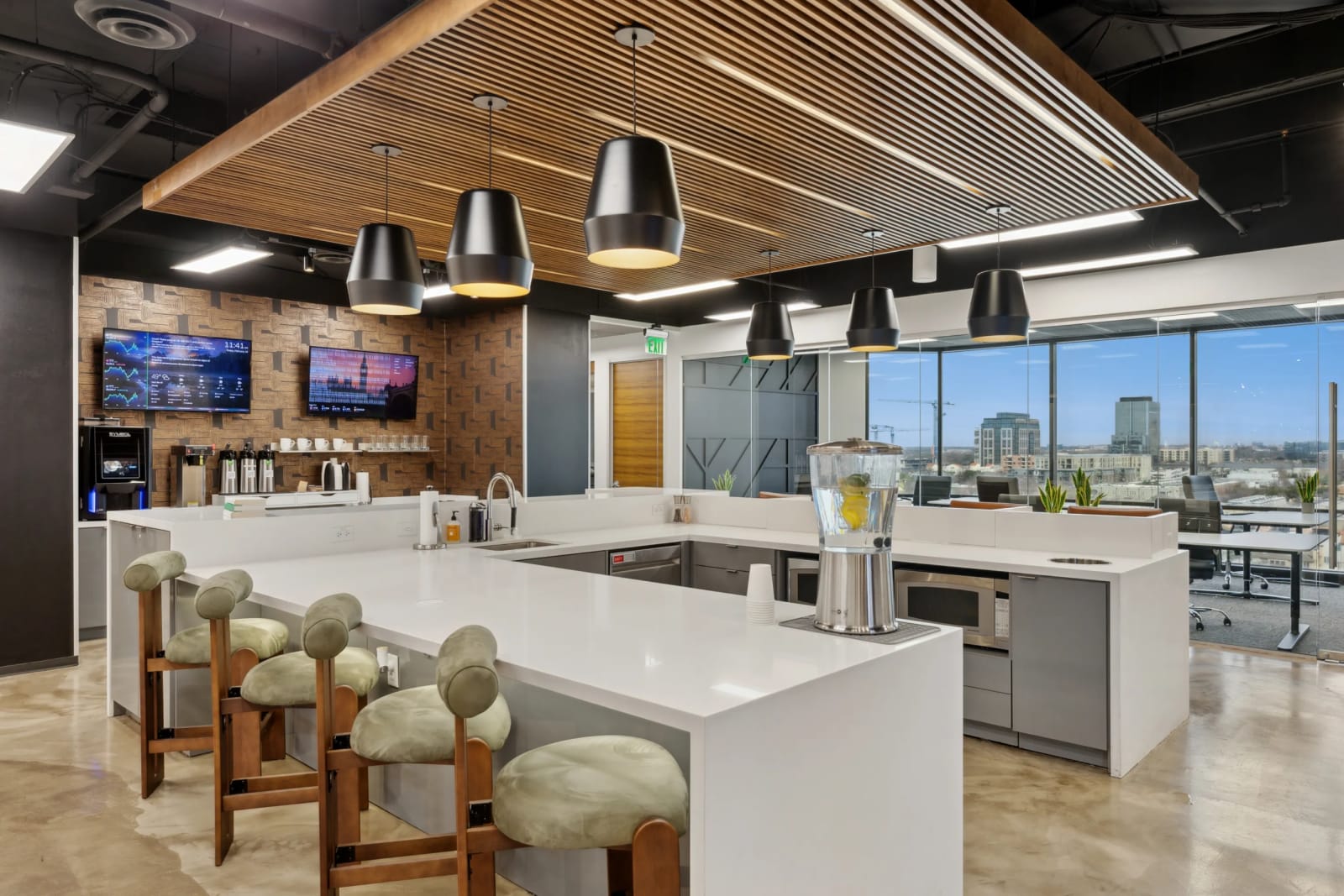 Coffee bar lounge at Lucid Private Offices Uptown Dallas with warm pendant lighting and bar seating
