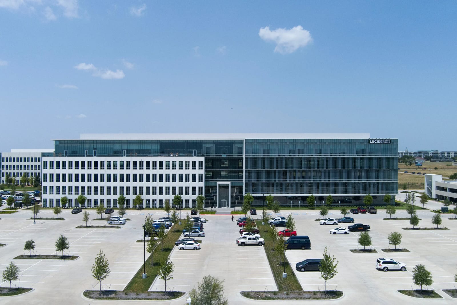 Aerial view of Lucid Private Offices West Plano office campus with parking and landscaping