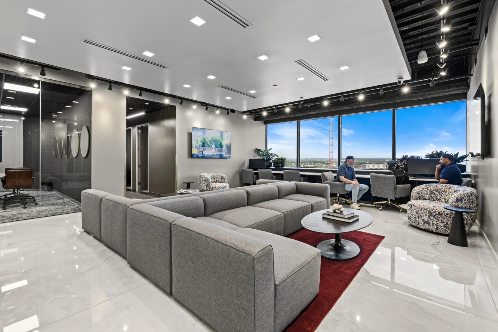 Lounge area at Lucid Private Offices Midtown / Music Row with modern seating, city views, and workspace.