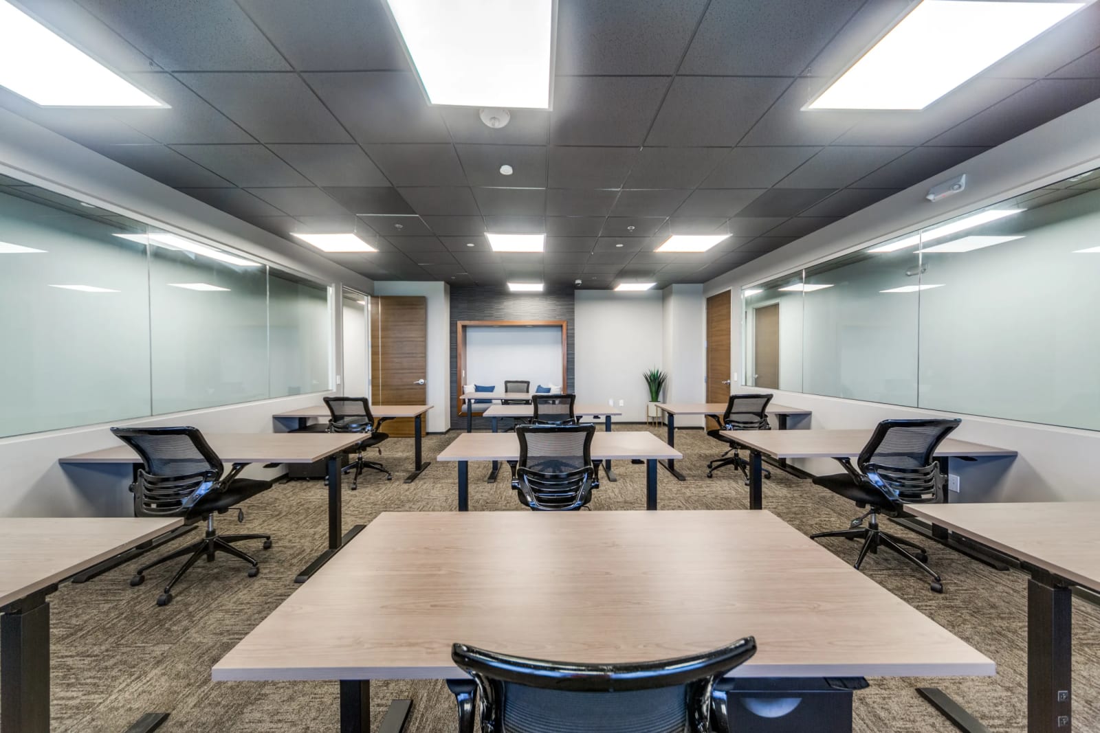 Team room with glass walls and a casual seating space in front.