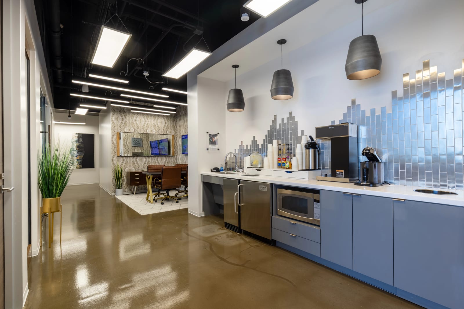 Member lounge at Lucid Private Offices Fort Worth Sundance Square with leather bench seating, coffee bar, and patterned accent wall