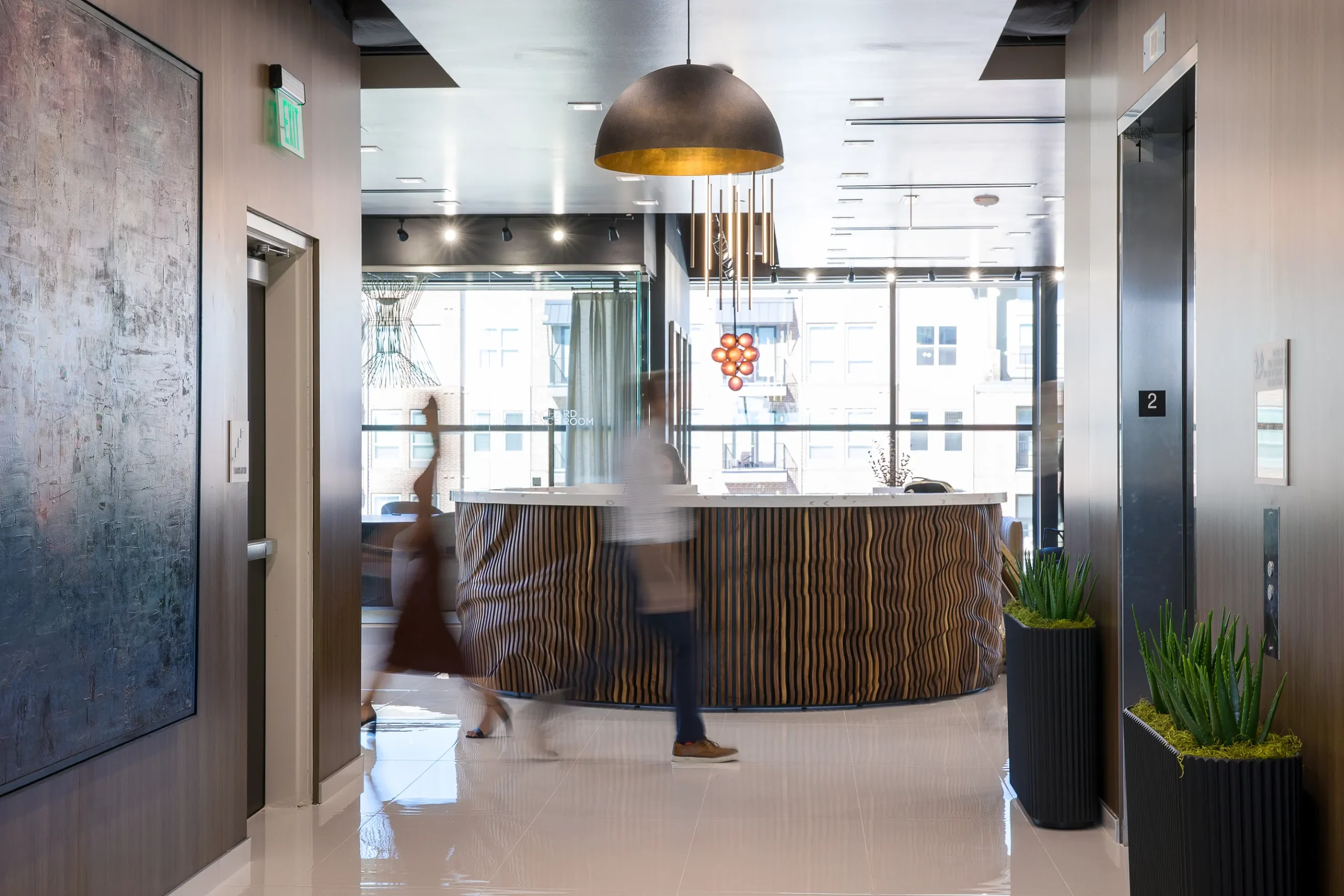 Blurred people walking by reception desk at Lucid Private Offices - Grapevine / Coppell