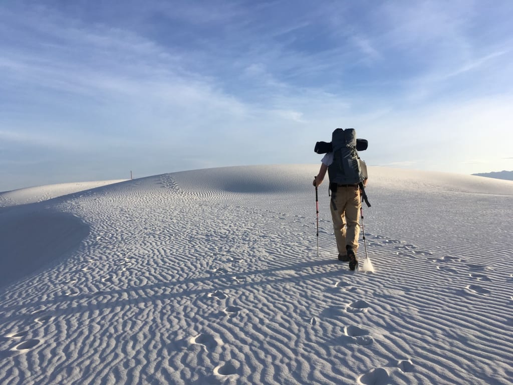 Homem escalando montanha nevada