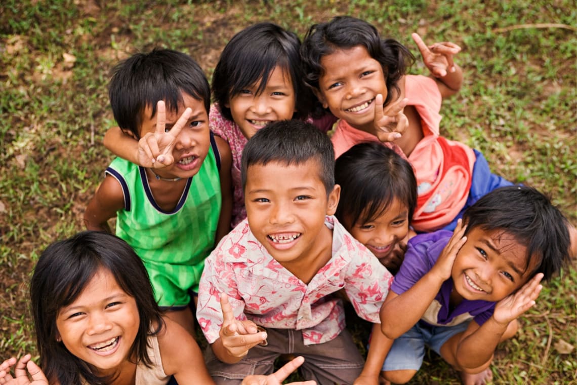 Cambodian children smiling and waving at the camera