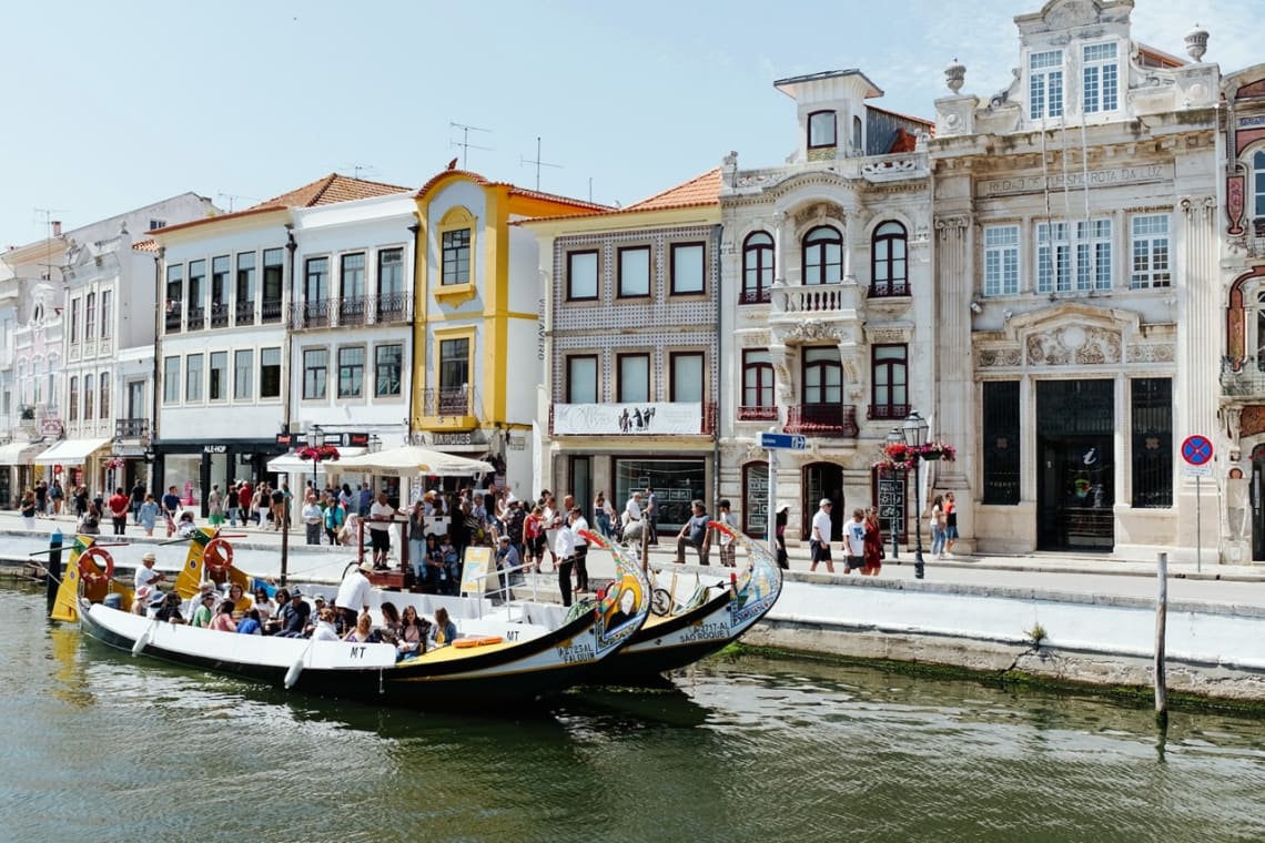 Botes con turistas por un canal en Aveiro, una de las ciudades de Portugal más bonitas