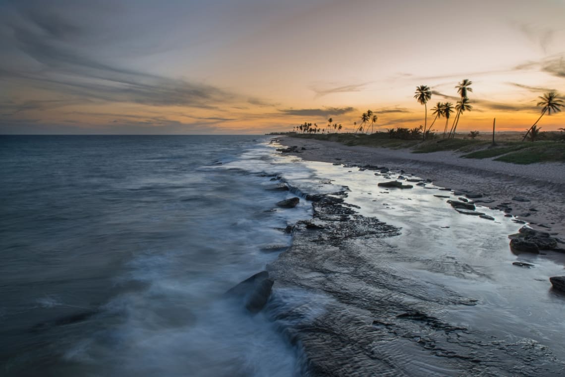 Playa con olas al atardecer en la Aldeia Hippie