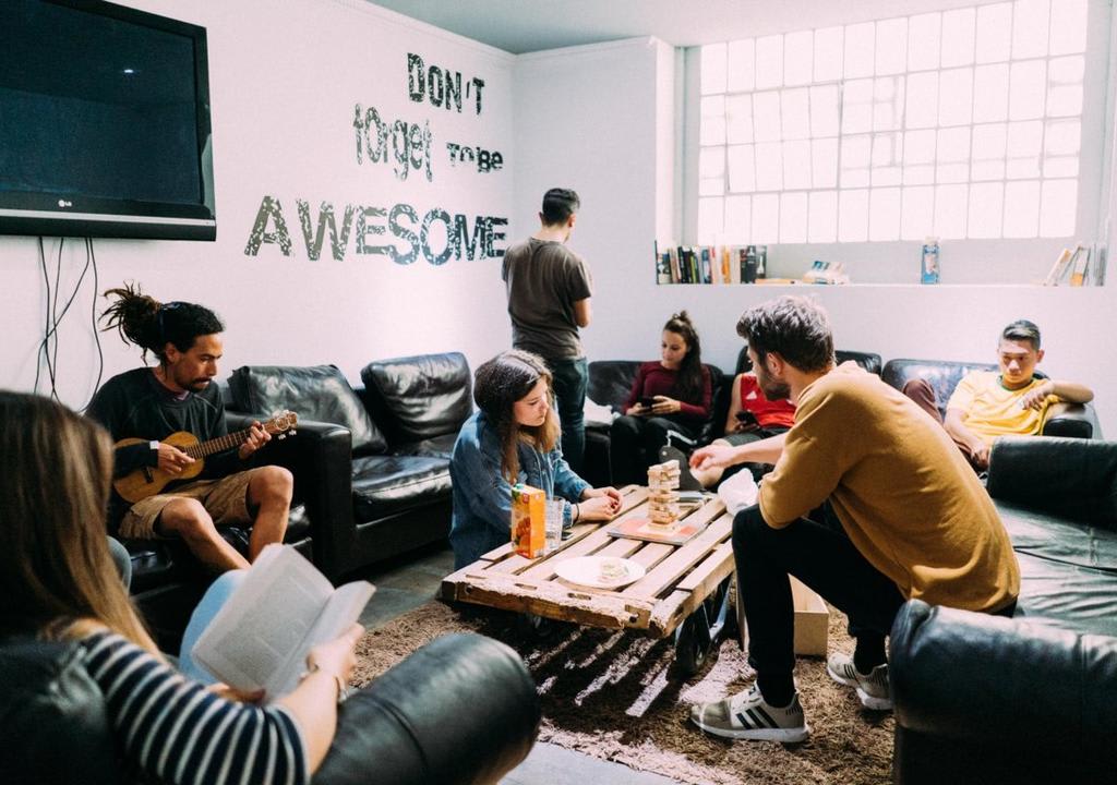 jovens interagem na área comum de um albergue durante voluntariado