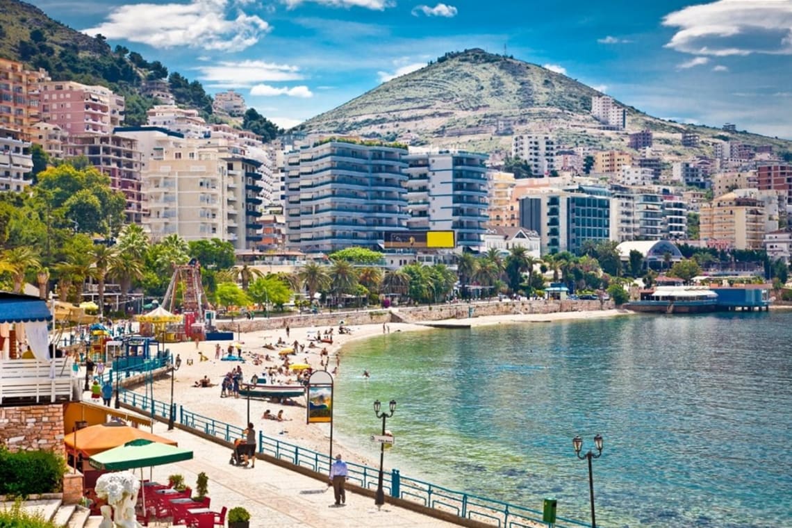 Playa de ciudad en Albania con  colina de fondo