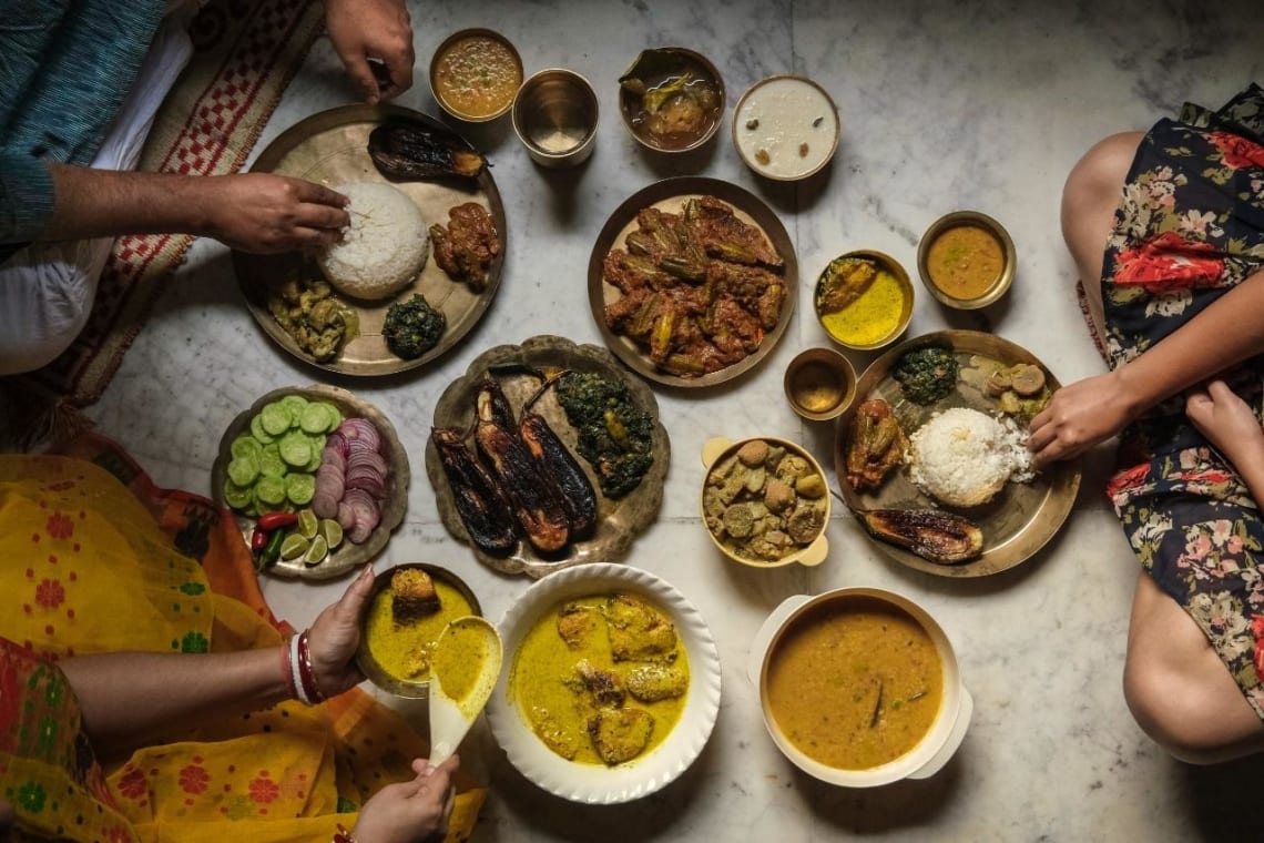 Turismo gastronómico en India: tres personas compartiendo distintos platos
