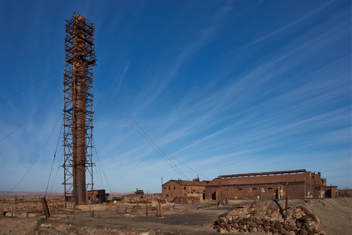 Alta chimenea y construcciones abandonadas de las antiguas oficinas salitreras&nbsp;