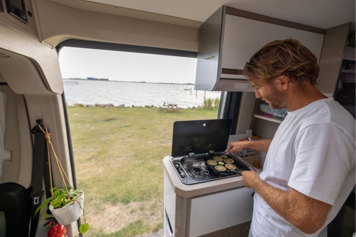 Mobile living: man cooking inside his van