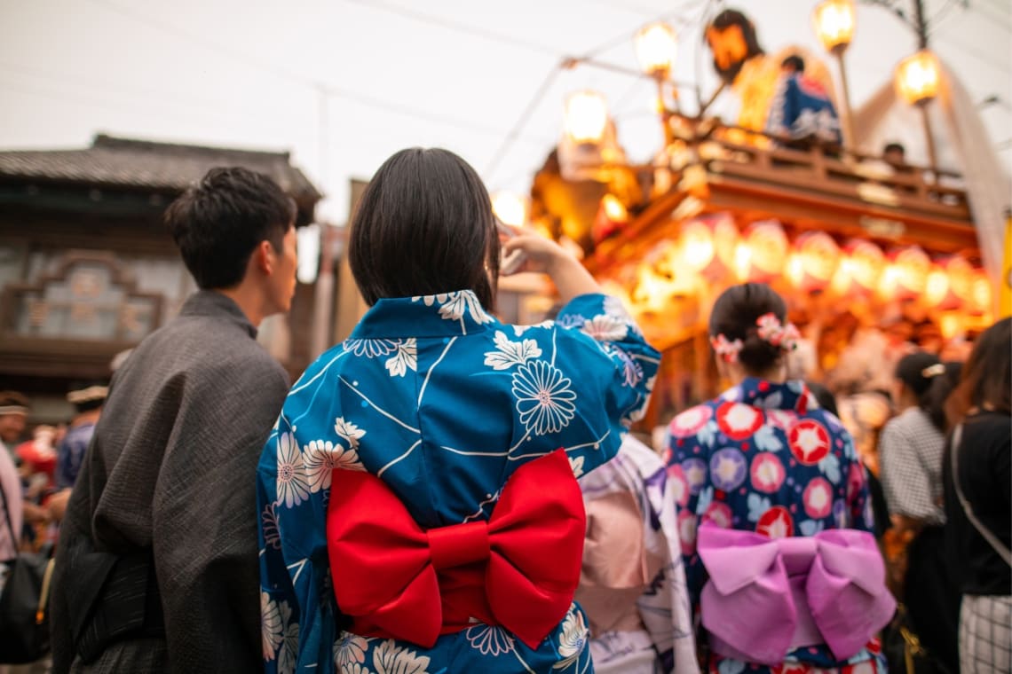 Japanese couple taking a picture of a chariot during Gion Matsuri Festival