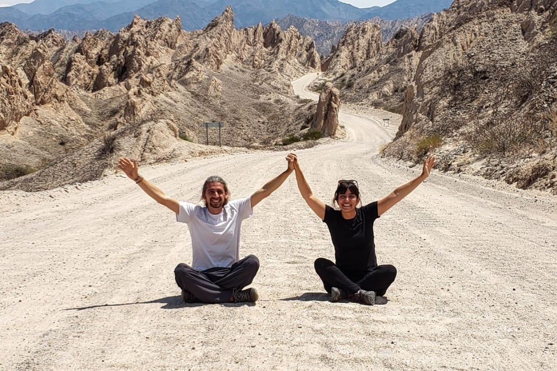 Mi novia y yo sentados en la ruta de tierra que conecta Cachi con Cafayate