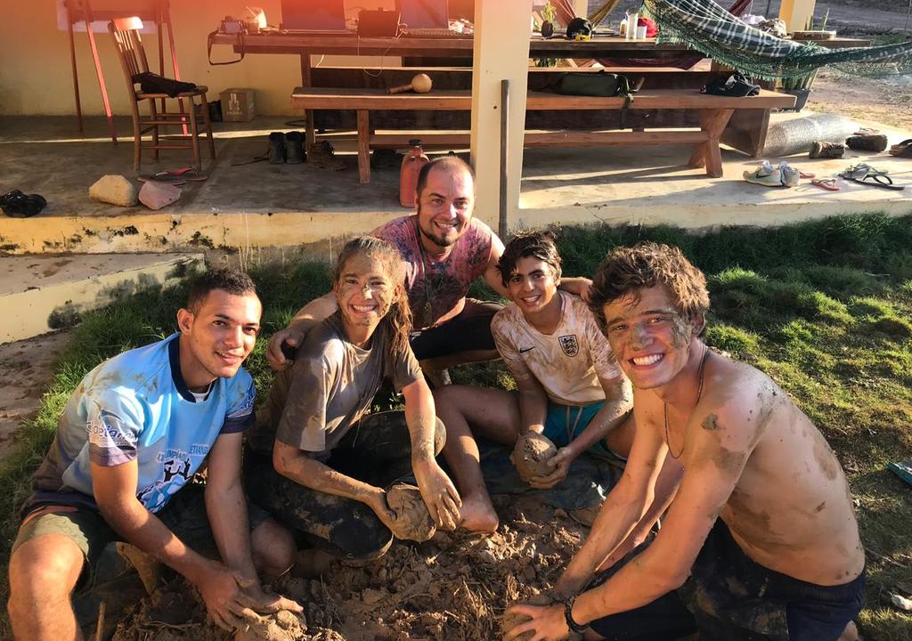 Five volunteers working on a farm with mud