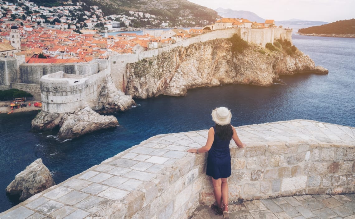 Chica mirando hacia la ciudad de Dubrovnik desde un mirador